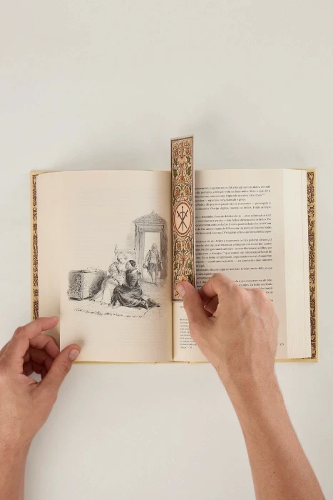 Livro aberto numa ilustração de Maurice Leloir, com o marca-página temático entre as páginas